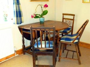 卡恩Calne Bed and Breakfast的一张带两把椅子的木桌和一盆盆盆栽植物