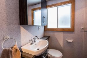 Saint-Tite-des-Caps卢克圣提特轻松木屋的一间带水槽和卫生间的浴室以及窗户。