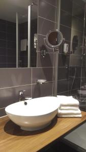 巴特朗根萨尔察Sante Royale Hotel- & Gesundheitsresort Bad Langensalza的浴室内一个柜台上的白色水槽