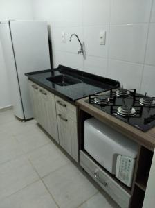圣安热卢AP Confortável San Inácio的厨房配有炉灶、水槽和冰箱。