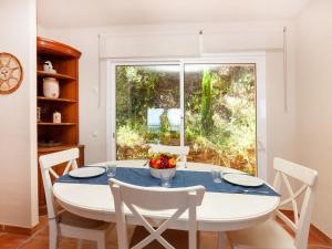 巴古尔Holiday Home Xarmada Guillermo by Interhome的一间带桌椅和窗户的用餐室