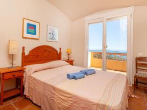 巴古尔Holiday Home Xarmada Guillermo by Interhome的一间卧室设有一张床,享有海景