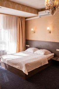 鄂木斯克Malibu Hotel的一间卧室设有一张大床和一个窗户。