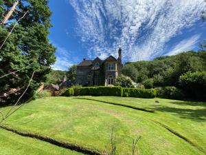 艾恩布里奇Coalbrookdale Villa的一座位于草地山丘上的老房子,有大院子