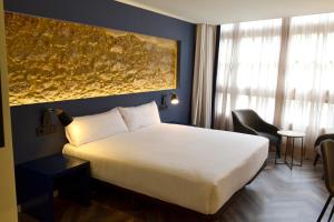 拉科鲁尼亚Hotel Alda Galería Coruña的卧室配有白色的床和墙上的大画作