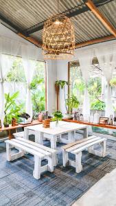KangkakawalBeanbag Bintan Backpacker的一间设有白色桌子和长凳的用餐室