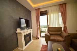 兹拉蒂博尔Zlatibor Hills Afrodita & Spa的带沙发、电视和壁炉的客厅