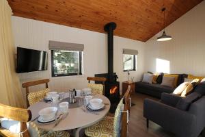 洛亨黑德Cosy Modern Nordic Lodge w/ Loch View & Log Burner的客厅配有桌子和沙发