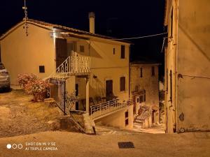 巴尼圣菲利波Bagni San Filippo Casa gelsomino的街上的一栋老房子,晚上有楼梯
