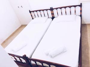 阿提蒙Artemonahi Traditional Cosy House的白色墙壁客房的两张床