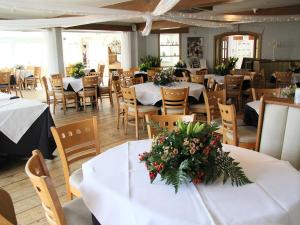希灵登水畔运河别墅酒店的餐厅设有白色的桌椅和鲜花