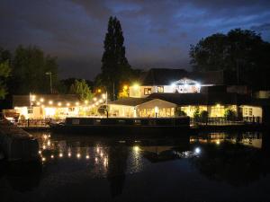 希灵登水畔运河别墅酒店的夜间在水中泛舟,灯光照亮