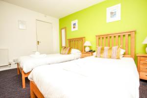 圣阿格尼丝Driftwood Spars的绿墙客房内的两张床