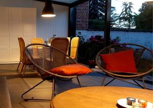 哈瑟尔特De Villo的一组椅子,配有橙色枕头和一张桌子