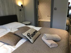 布莱顿霍夫EI8HT Brighton Guest Accommodation的一张带两个枕头的床和毛巾