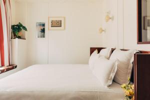 巴黎Hôtel Wallace - Orso Hotels的卧室配有白色的床铺和白色的枕头