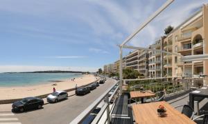 戛纳Fettolina Palm Beach, Location Cannes front de mer et plage的从酒店阳台可欣赏到海滩景色