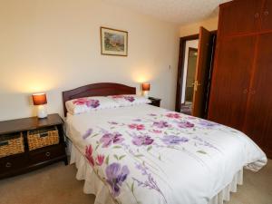 尤托克西特Summerfields的一间卧室,床上有紫色鲜花