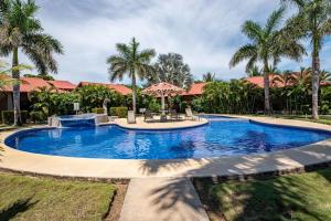瓜纳卡斯特Claudia Villagge的棕榈树庭院里的一个大型游泳池