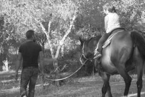 恩纳罗西别墅 的一位马匹上带领小女孩的人