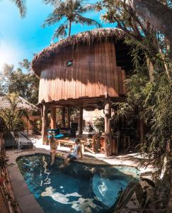 吉利特拉旺安Gili Treehouse的度假村内带游泳池的小屋