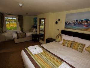 韦斯特贝The George的酒店客房设有两张床和大窗户。