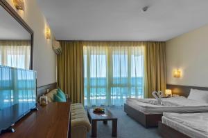 阳光海滩Hotel Glarus Beach的酒店客房,设有两张床和一张沙发