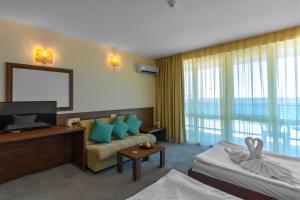 阳光海滩Hotel Glarus Beach的一间配备有沙发及电视的酒店客房
