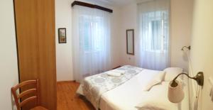 科米扎Guest House Marina的卧室配有白色的床和2扇窗户。