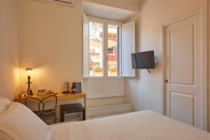 罗马Ripagrande a Trastevere的一间卧室配有一张床、一张书桌和一个窗户。