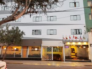 利马Hotel Dia y Noche的前面有旗帜的建筑