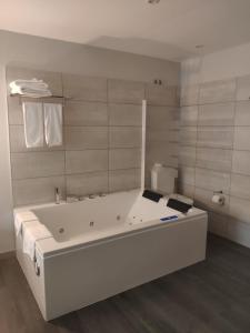 卡尔达斯·德·雷斯Motel Caldas的白色的浴室设有浴缸和卫生间。