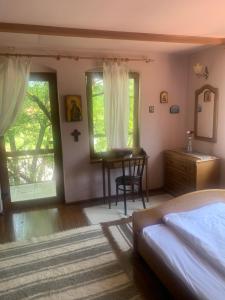 科尔贝尼vila zia的一间卧室配有一张床、一张书桌和窗户。