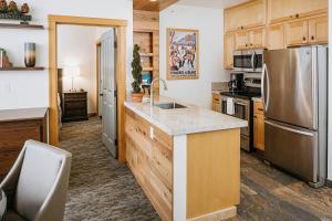 马姆莫斯湖瞻博温泉度假酒店的厨房配有木制橱柜和不锈钢冰箱。