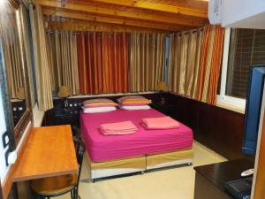 埃拉特Shefer Guesthouse的一间小卧室,配有粉红色的床和一张书桌