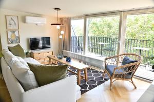 贝恩堡JETHON Exklusives City-Appartement Bernburg的带沙发和电视的客厅以及阳台。