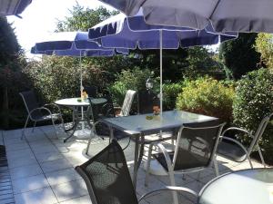 诺德施泰特北欧酒店的庭院里配有两张桌子和椅子以及遮阳伞