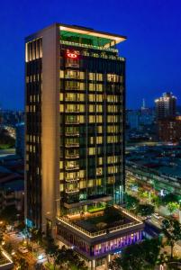 台北杰仕堡有氧酒店的一座高大的建筑,上面有灯,晚上