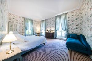 索尔格Chambre d'hôtes Château Gigognan的一间卧室配有一张床和一张蓝色的沙发