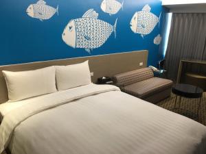 嘉义市嘉义乐客商务旅馆的酒店客房,设有一张床,墙上有鱼