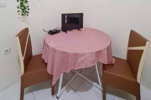 茂物Pesona Wisata Alam Ciparay Endah Mitra RedDoorz的一张粉红色的桌子,上面有一台电视