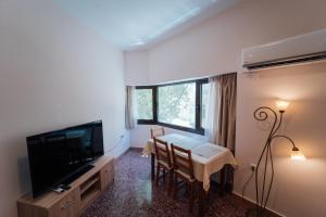 雅典Luxury Apartment in Plaka - Acropolis (Rosemary)的客厅配有桌椅和电视