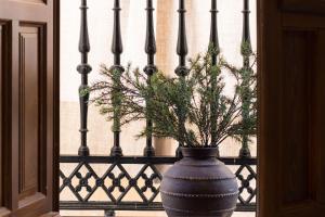 格拉纳达Riad Alhambra by Apolo Homes的蓝色的花瓶,在围栏旁边植有植物
