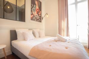 波尔多Magnifique appartement avec 3 chambres en Hypercentre的一间卧室配有两张带白色床单的床