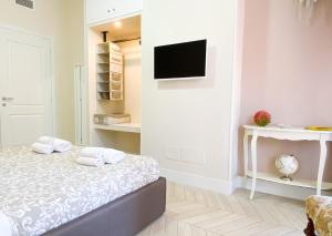 罗马Trastevere Boulevard的一间卧室配有一张床,墙上配有电视