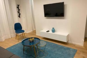 巴黎Stylist and cosy appartement in Montparnasse的客厅配有桌子,墙上配有电视