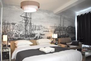 迪耶普Villa Castel Chambres d'hôtes B&B的卧室配有一张大床,墙上挂有绘画作品