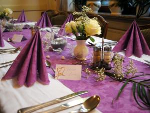 维尔施涅多夫沃德斯伍旅馆的一张桌子,上面有紫色的桌布,布上花和餐巾