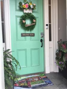 新奥尔良WG Creole House 1850的绿色的门,上面有欢迎标志