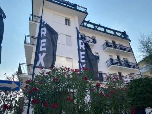 丽都迪萨维奥Hotel Rex的前面有旗帜和鲜花的建筑